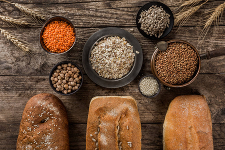 不同的新鲜面包和面粉产品意大利面在乡村木制背景上。 由面包制成的创意布局。 健康食品概念俯视图平视复印空间