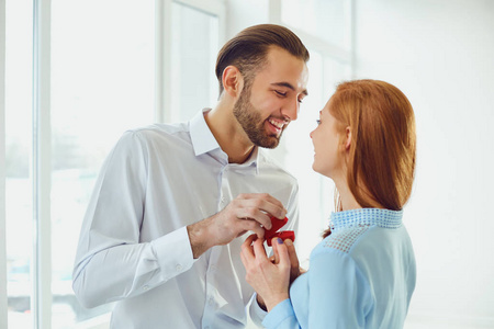 男人向一个窗户明亮的房间里的女孩求婚