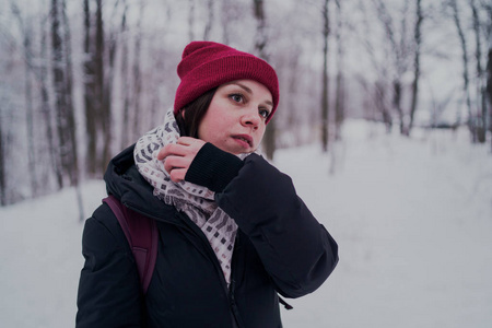 这个女孩在冬天的树林里休息。 在冬天的公园里，年轻的女人在雪地里散步