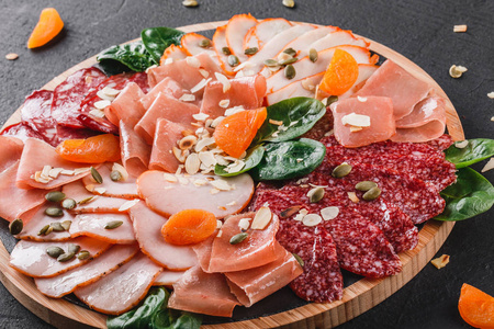 荞麦粥配以白盘上的荤食在黑石背景上,在切割板上