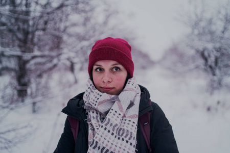 这个女孩在冬天的树林里休息。 在冬天的公园里，年轻的女人在雪地里散步