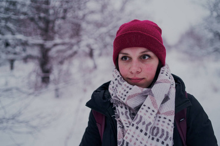 这个女孩在冬天的树林里休息。 在冬天的公园里，年轻的女人在雪地里散步