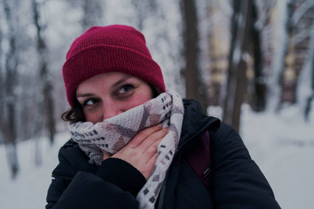 这个女孩在冬天的树林里休息。 在冬天的公园里，年轻的女人在雪地里散步