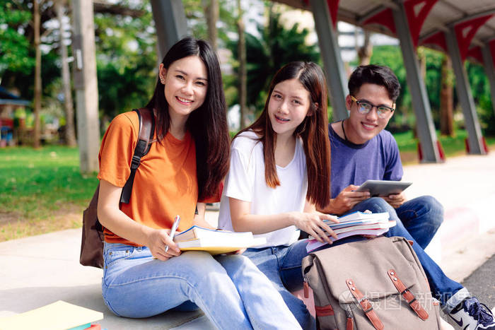 照片 三个亚洲年轻人一起在户外学习.教育与技术理念.