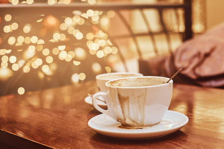 在咖啡店的木桌上放了两杯咖啡, 用 bokeh 效果模糊背景照片