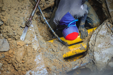 技术员正在修理地下水管坏了.