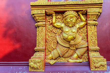 美丽的金妖雕，在清迈的WatSrisupan寺的公共佛教教堂墙上，承载着这座建筑。泰国。