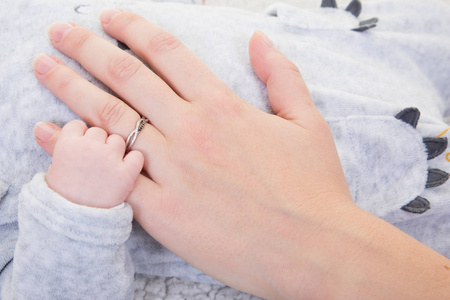 新生儿的手抓住母亲的手指