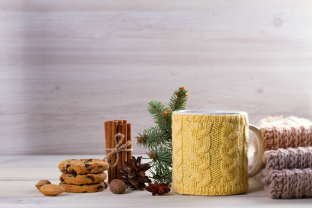 针织黄色杯与炎热的冬天喝饼干肉桂冬季装饰。 温暖舒适的气氛，而寒冷的季节。 复制空间