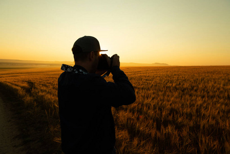 人在日出时在田野里拍照
