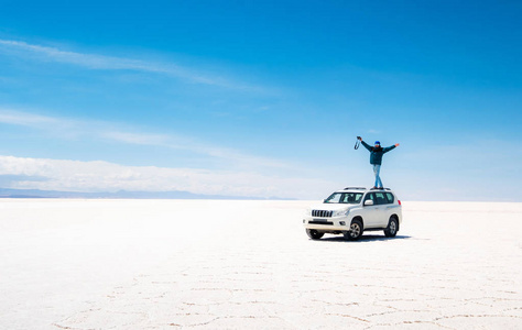 男子站在阳光下的汽车 salar de uyuni