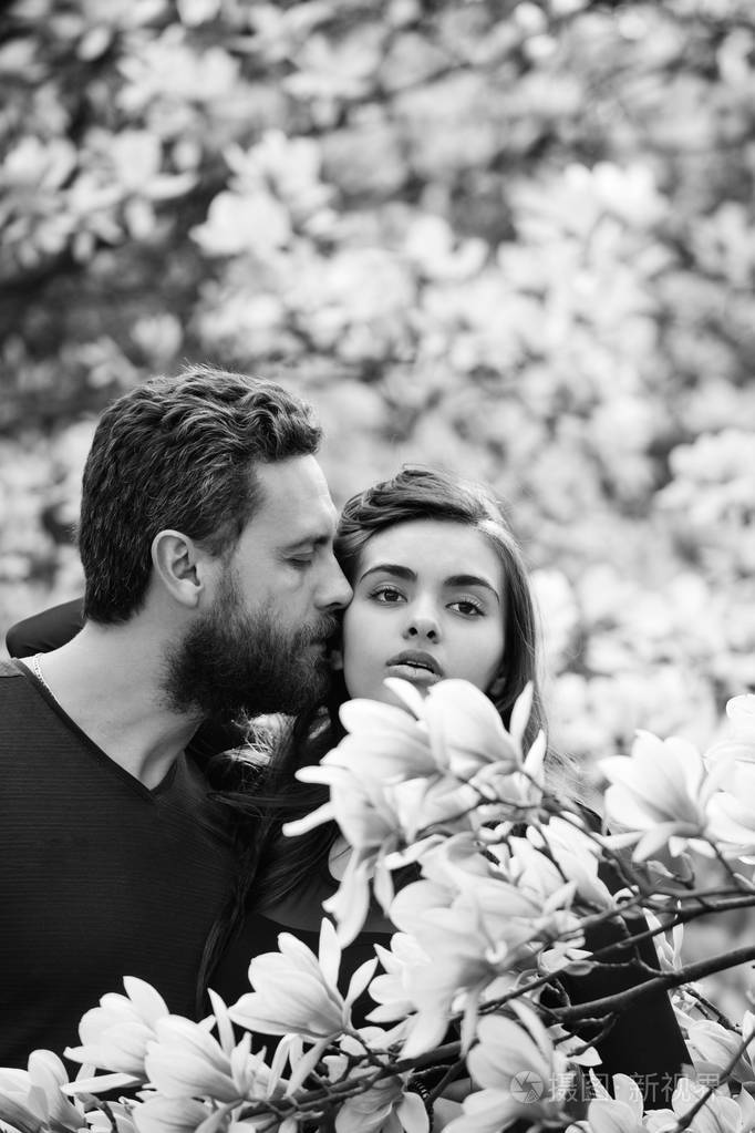 夫妇爱情男人亲吻女人在开花的树玉兰
