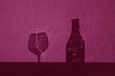 酒瓶和玻璃阴影粉红色。 抽象的背景和视图。
