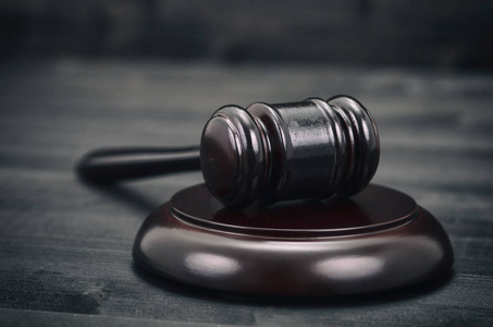 法律和司法合法性概念法官木槌在一个黑色的木制背景.照片