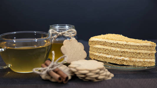 蜂蜜蛋糕躺在碟子上。 杯子和茶壶里的绿茶。