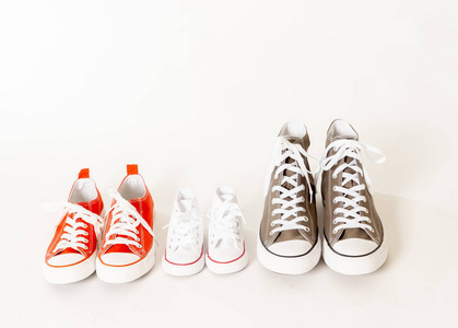 父母和儿子女儿胶鞋运动鞋的概念形象，在白色背景下，不同大小的复制空间，在一起，家庭育儿教育和生活方式概念。