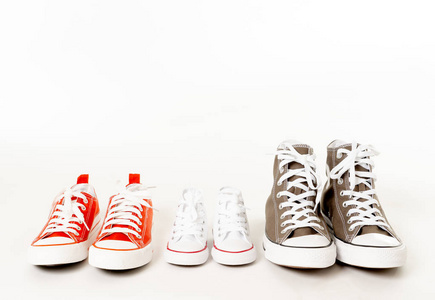 父母和儿子女儿胶鞋运动鞋的概念形象，在白色背景下，不同大小的复制空间，在一起，家庭育儿教育和生活方式概念。