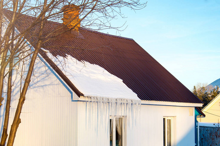 小白宫有冰柱住宅建筑在冬天的一天，屋顶上有一点雪在阳光下，水平射击