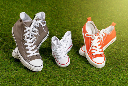 概念形象家庭胶鞋运动鞋的父亲，母亲和儿子，女儿在绿草上，男人，女人和孩子在快乐的时刻在一起，家庭育儿教育和生活方式的概念。