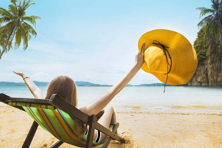 女人在沙滩上休息时戴着帽子