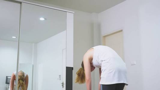 女人在她的公寓里靠近镜子。健康生活方式的概念, 而不是职业运动