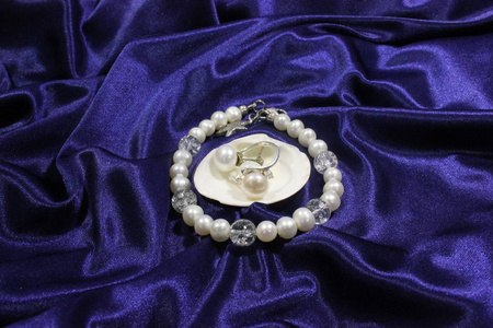 白色淡水珍珠和贝壳在蓝色背景上的珠宝。 手工。