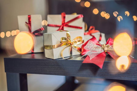 圣诞礼物用手工纸包裹，上面有红色和金色的丝带。
