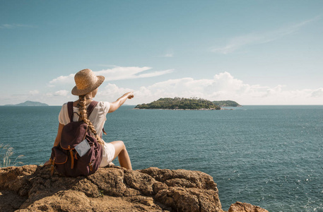 戴草帽的女孩旅行者，岩石海洋景观