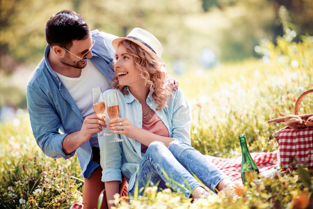 喜欢约会的人和庆祝的概念，微笑的夫妇在野餐时喝香槟。