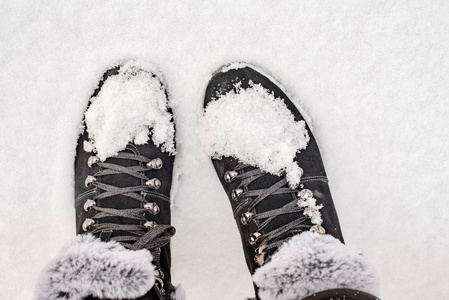 s boots with fur in the snow. Winter has come, dress warmly.