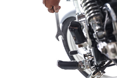 用扳手在白色背景的摩托车上裁剪的机械师视图