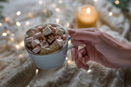 女人手拿一杯热可可与棉花糖针织布为一个杯子圣诞节概念冬季背景圣诞装饰传统饮料