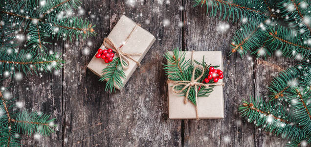 圣诞背景与圣诞礼物在木制背景与冷杉枝。 圣诞节和新年快乐作文。 平躺式顶部视图