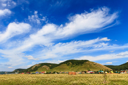 在夏日阳光明媚的日子里，乡村的风景群山蓝天和云彩