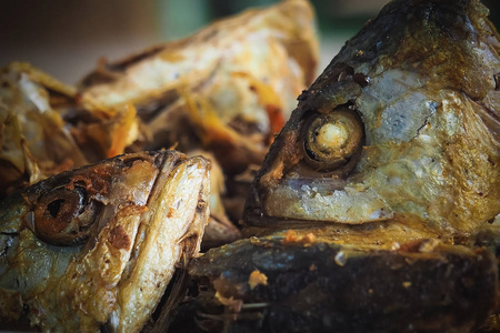 炸鱼头做泰国农村居民的简餐图片