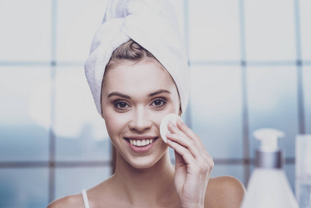 面程序..年轻漂亮的女人站在浴室里，一边洗脸，一边用化妆品卫生用品擦拭，一边表达着幸福