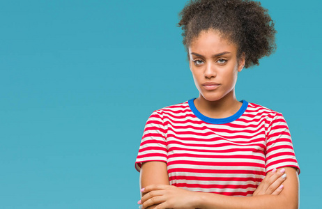 年轻的非洲美国妇女超过孤立的背景怀疑和紧张的不赞成的表情在脸上交叉的手臂。 消极的人。