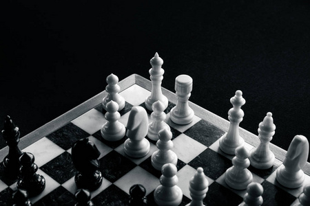 在棋盘的背景下，白色棋子抵御黑色棋子