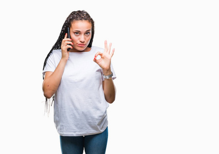 年轻的发非洲裔美国女孩显示使用智能手机在孤立的背景下打电话，做OK标志手指优秀的符号
