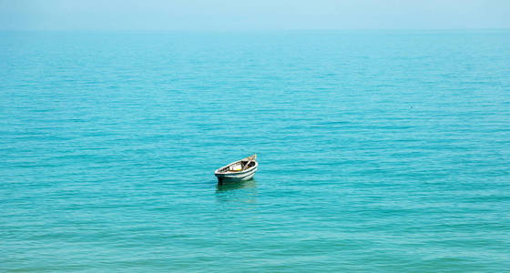 温柔柔和的美丽画面,平静的大海景观与一艘古老的渔船.