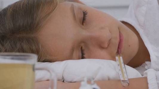 生病的孩子卧床不起生病的孩子带体温计的女孩住院吃药