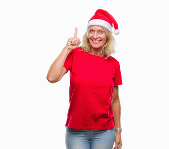 中年金发女人戴着圣诞帽，在孤立的背景上指点着成功的想法。 退出并快乐。 一号。