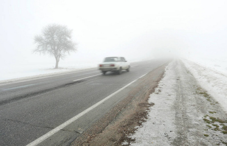 汽车在通往雾的道路上行驶图片