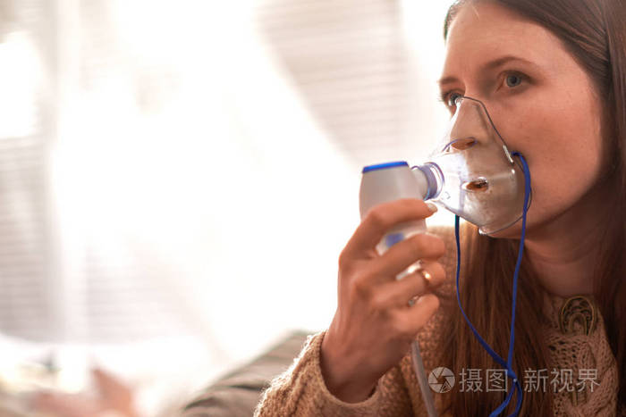 拿着面罩,雾化器吸入烟雾,把药物喷进你的肺部生病的病人.