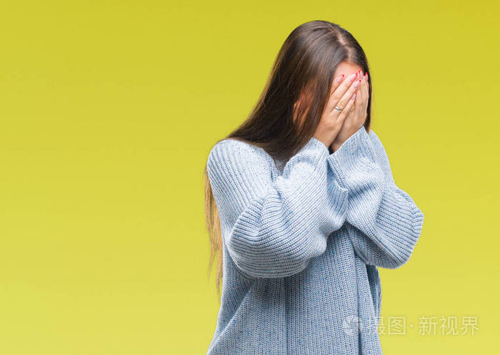 年轻美丽的白种人女人穿着冬天的毛衣在孤立的背景上悲伤的表情用手