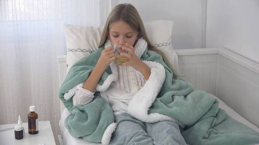 生病的孩子喝茶生病的孩子在床上受苦的女孩病人住院