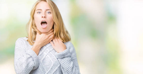 美丽的年轻女子穿着冬天的毛衣,在孤立的背景上大喊大叫,因为痛苦的