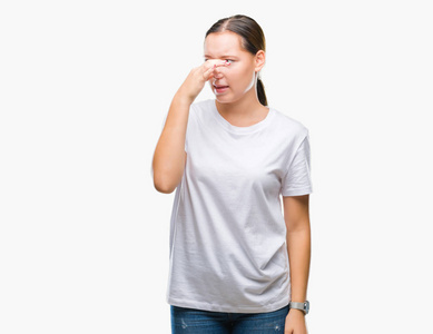 的白种人女人在孤立的背景上闻到一些臭味和令人恶心的难以忍受的气味