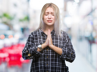 年轻的金发女人在孤立的背景下乞讨和祈祷，双手和希望的表情在脸上非常情绪化和担心。 请求原谅。 宗教观念。