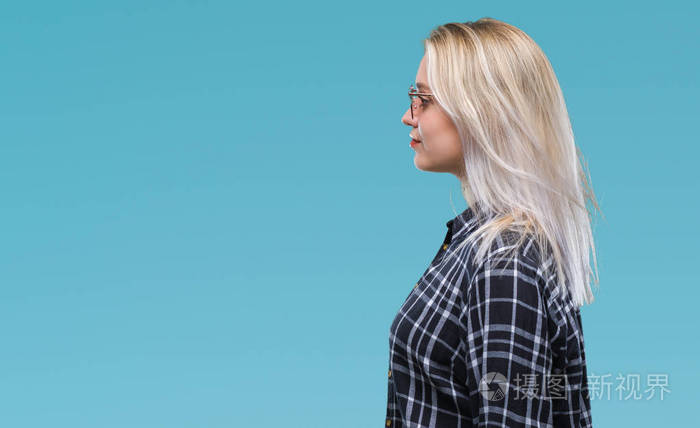 年轻的金发女人戴着太阳镜,在孤立的背景上,看着侧面放松的轮廓,自然